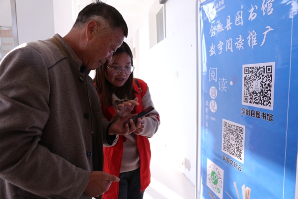 志愿者現(xiàn)場向老人講解如何使用數(shù)字閱讀.JPG
